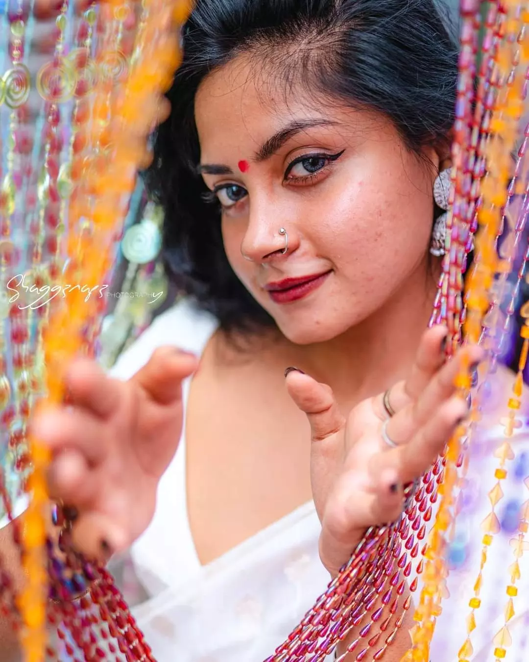 Desi fashion portrait photoshoot reaching through a bead curtain, Colombo, Sri Lanka